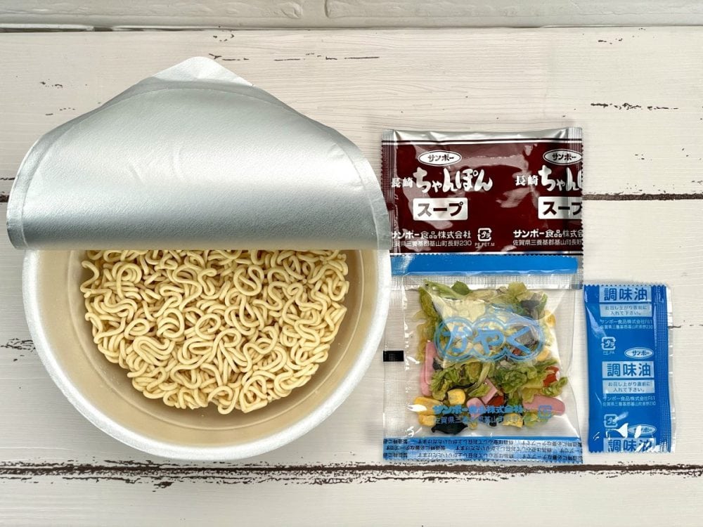 サンポー食品「九州三宝堂 長崎ちゃんぽん」カップ麺の構成は粉末スープ・乾燥かやく（キャベツ・キクラゲ・コーン・かまぼこ・にんじん）・調味油