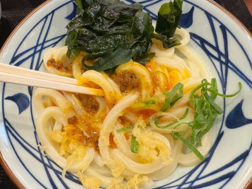 好きなだけ薬味を入れたら、うどん＆卵とよく絡めて……