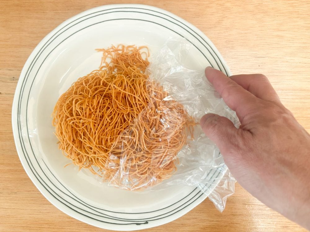 「長崎皿うどん」の作り方はまず麺を皿に移し、麺の角を手で軽くほぐします