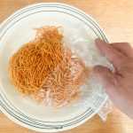「長崎皿うどん」の作り方はまず麺を皿に移し、麺の角を手で軽くほぐします