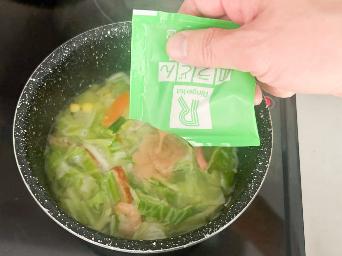 具材がほぐれて沸騰したら1度火を止め、スープを入れてとろみがつくまでよくかき混ぜます