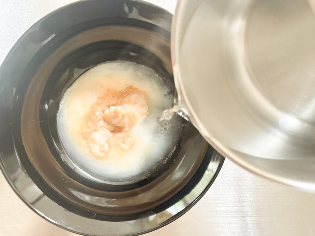 具付きの麺をレンチンしているあいだ、ラーメンどんぶりにスープと沸騰したお湯300mLを入れてラーメンスープを作ります