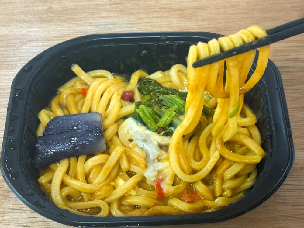「汁なしカレーうどん」はナス、ほうれん草、チーズ、赤ピーマンの具材入りで見た目も鮮やかです