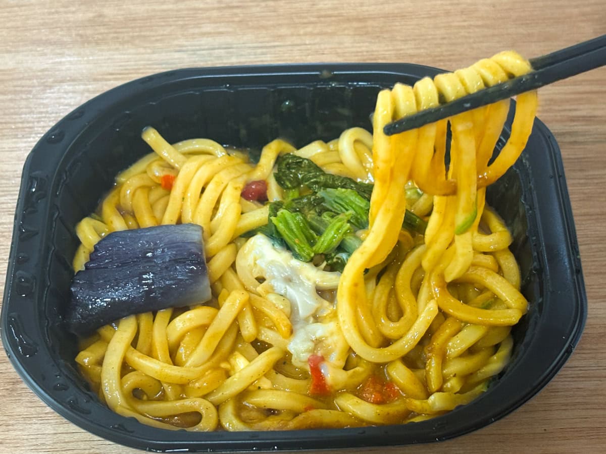 「汁なしカレーうどん」はナス、ほうれん草、チーズ、赤ピーマンの具材入りで見た目も鮮やかです