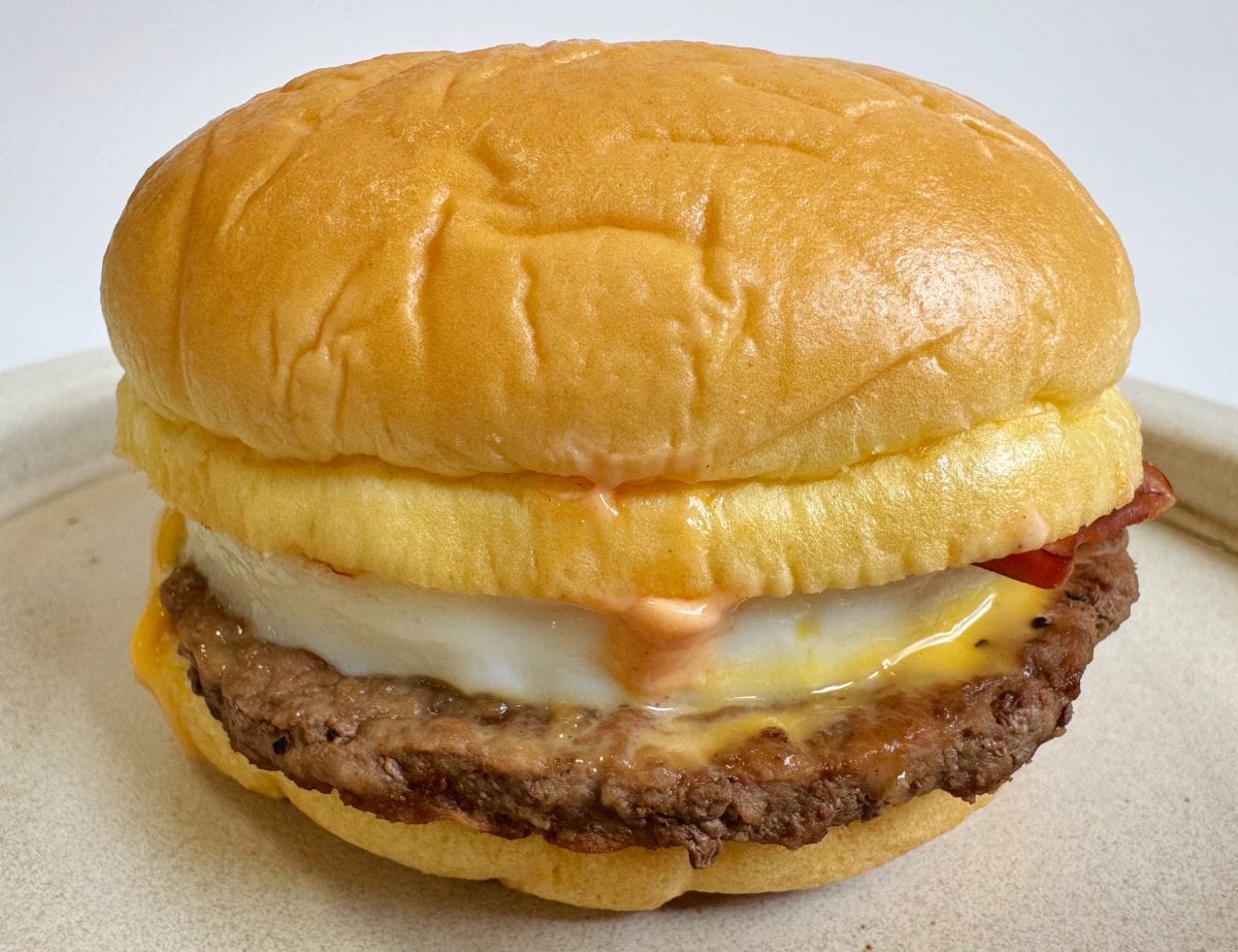 ふわもち食感のバター風味バンズの中には、ジューシーな100%ビーフパティ、スモークベーコン、たまご、チェダーチーズ、そしてすき焼きフィリングが挟まれており、リッチな組み合わせに