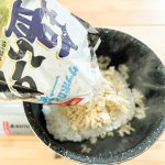 パックごはんの入った鍋に細かく砕いたインスタント麺を投入
