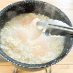 インスタント麺を投入したら軽くかき混ぜ、スライスしたむきエビ、ベーコン、しめじなどの具材を投入します