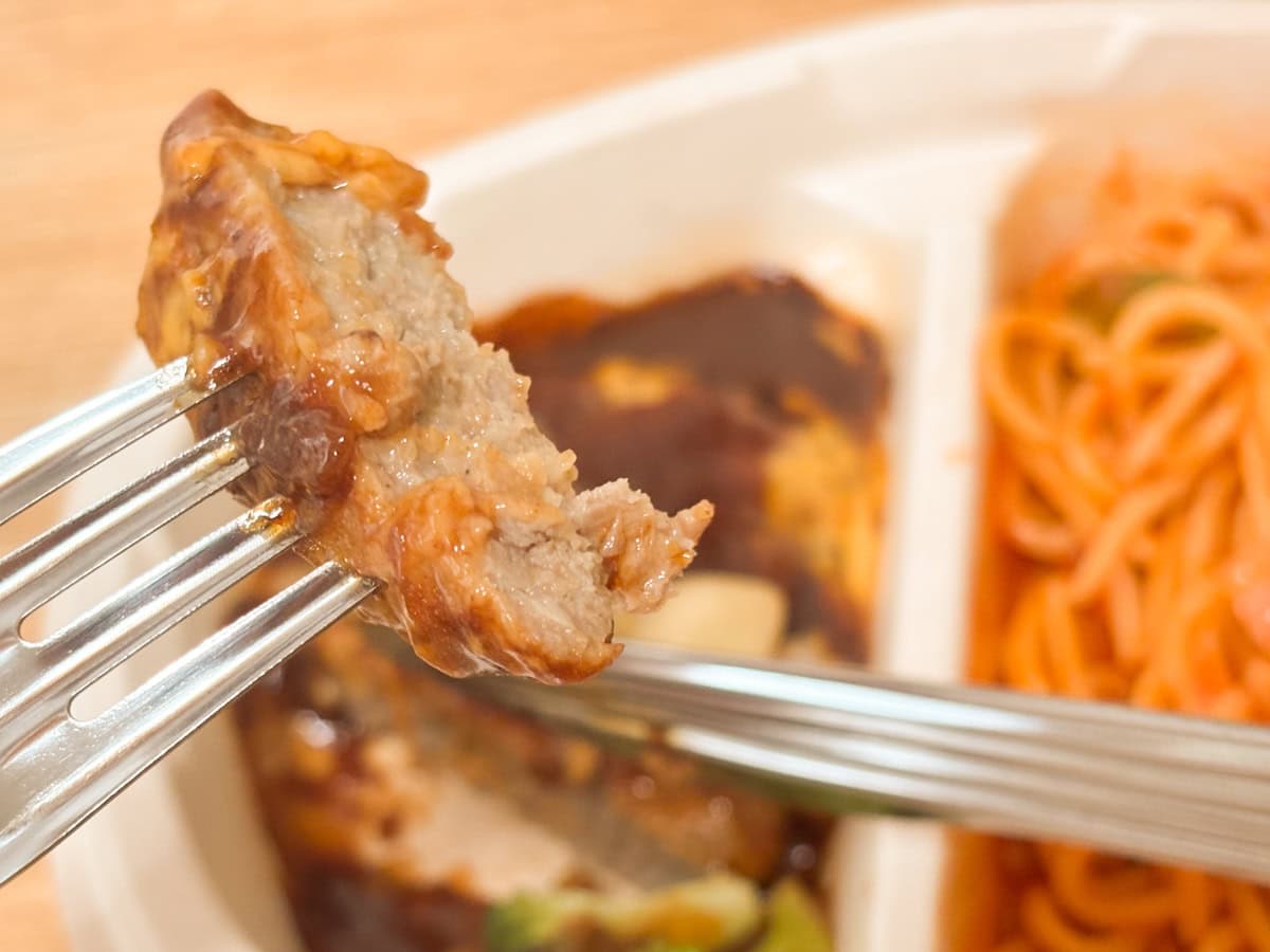 ニップン「よくばりプレート」シリーズの特徴なのか、「煮込み焼ハンバーグ＆ナポリタン」のハンバーグはふっくら系ではなくギュウギュウに詰まった肉肉しい感じ