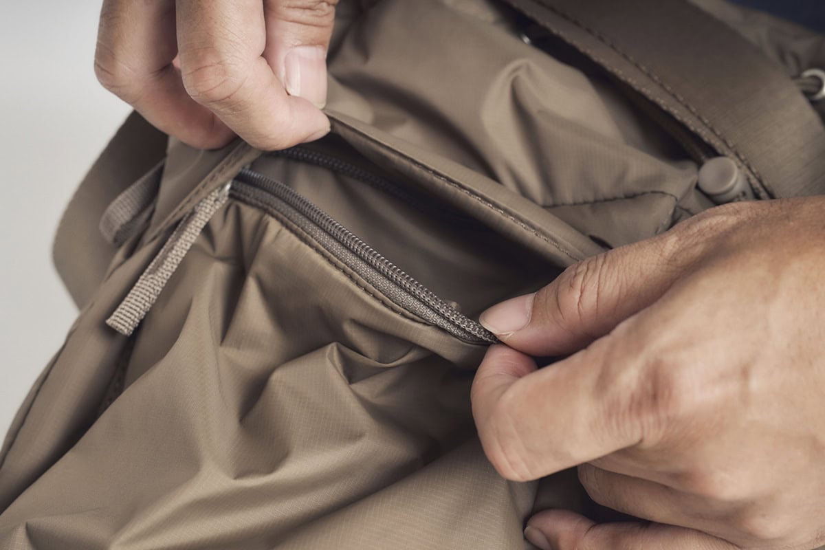 特徴的なフロントポケットは、フラップの下にファスナーを備えた構造