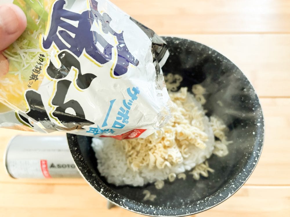 砕いたインスタント麺を投入し、パックごはんをほぐしつつかき混ぜる