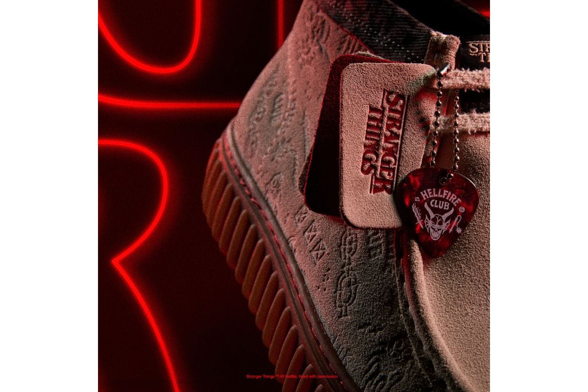 ギターピック型チャームや3種のスエードロゴフォブ、そしてデュアルブランドのシュータンラベルが細部を飾る