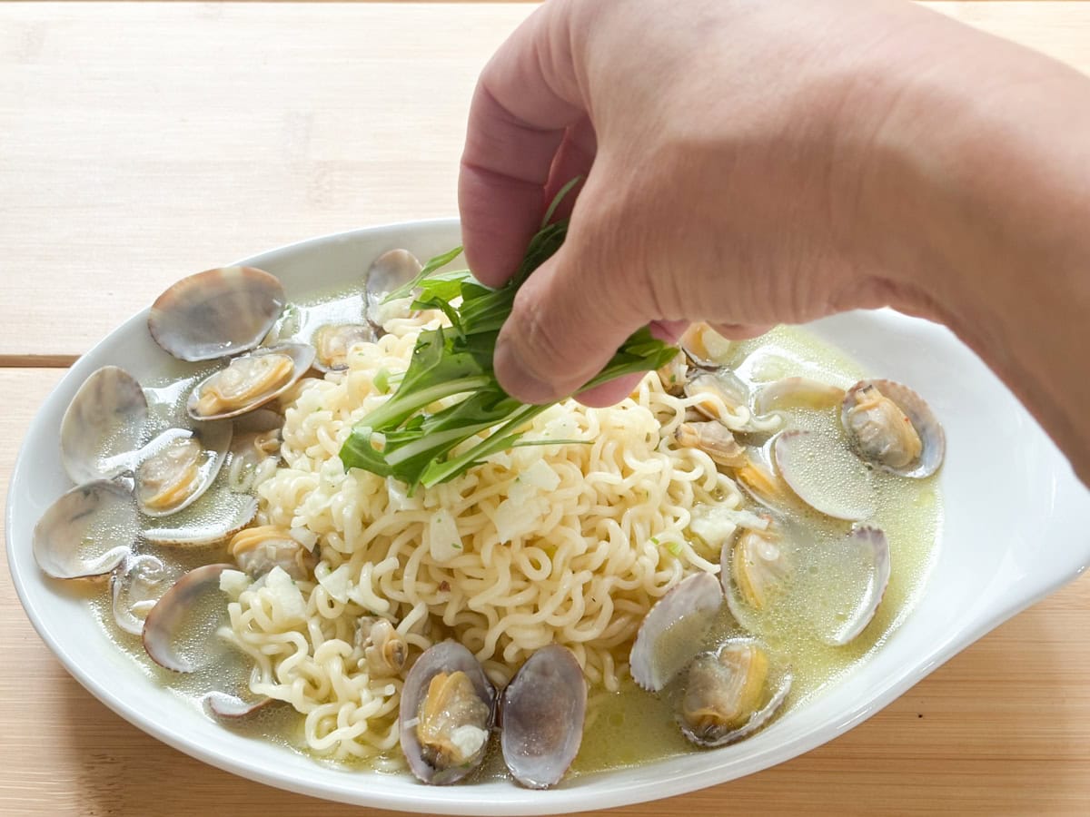 麺を皿に盛り付け水菜をトッピング。このレシピでは、付属の切り胡麻は使用しません