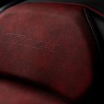 専用表皮を採用し、赤色ダブルステッチ縫製や専用シートタグなどを使用したレッド／ブラックのシート