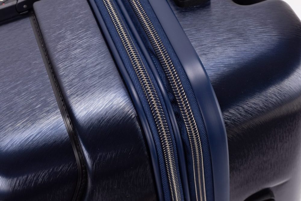 メタリックなコイル状ファスナーを採用し、質感と耐久性を高めるとともに、高級感と操作性を両立
