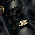 2つのアンティークゴールドのバックルと管をあしらったライディングブーツを思わせるハーネスストラップを装備