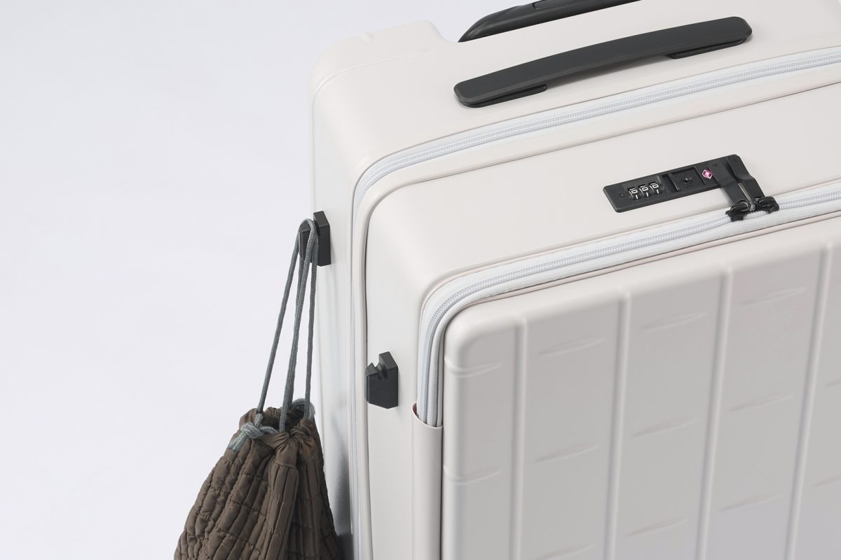 預け入れサイズのスーツケース側面に、土産袋などを掛けられるサイドフックを装備