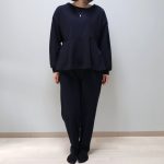 ネイビーのペプラム プルオーバーとタックパンツをセットアップ風に着用