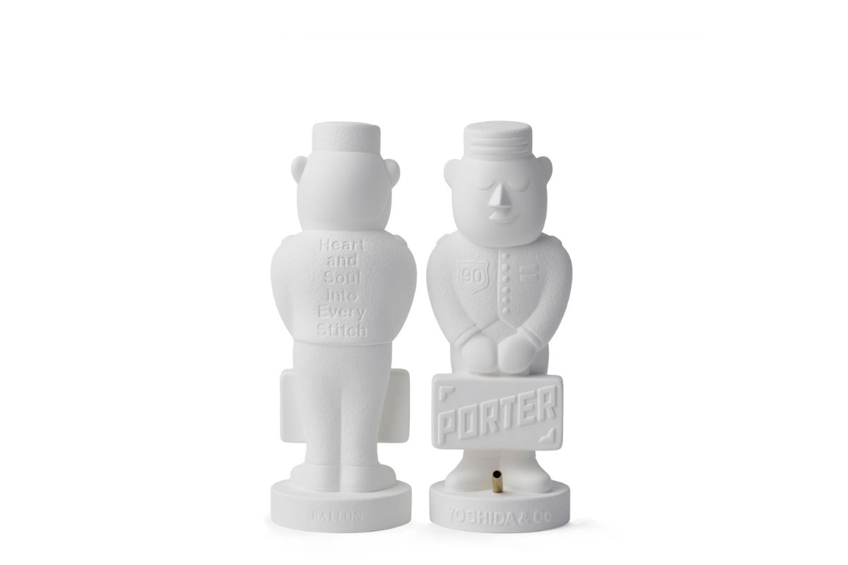 ポーターくんの胸に90周年のエンブレム、背中には吉田カバンのモットーである「一針入魂」を意味する「Heart and Soul into Every Stitch」の文字を表現