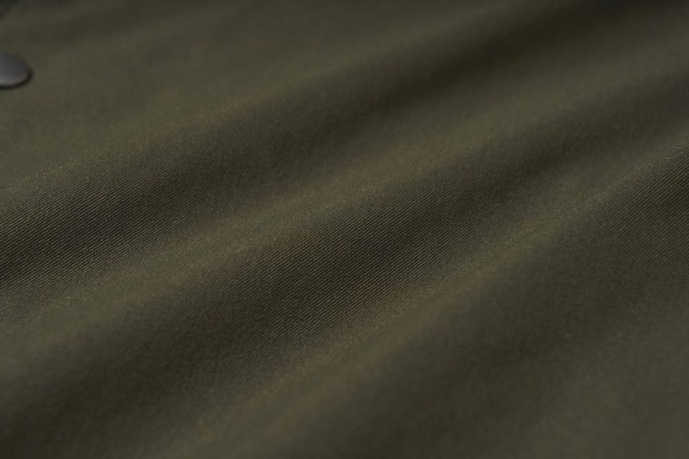 一般的なツイル（綾織り）生地よりも耐久性が高く、防風性やシワになりにくいのが特徴