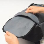 リュック下部に収納されたホルダーとフロント上部のベルトで、スケートボードを取り付けられる