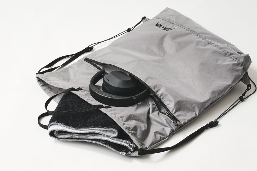 巾着型の開口部と正面にファスナーポケット