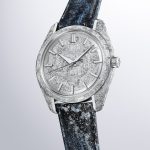 京都レザーによるストラップには、躍動感のある水の流れと岩にはじける水しぶきの輝きを、手加工の箔押しで表現