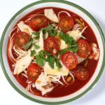 麵つゆをトマトジュースで割り、トマトとサラダチキンをトッピング。バジルの代わりに大葉を乗せたそうめん