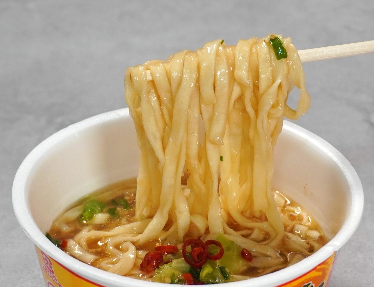 日清食品「日清のどん兵衛 博多もつ鍋〆風うどん」平打ちうどんはつるみがあって心地よい歯ごたえ