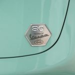 レッグシールド内側のグローブボックスリッドにはハニカムヘキサゴンデザインの80周年記念のロゴバッジ