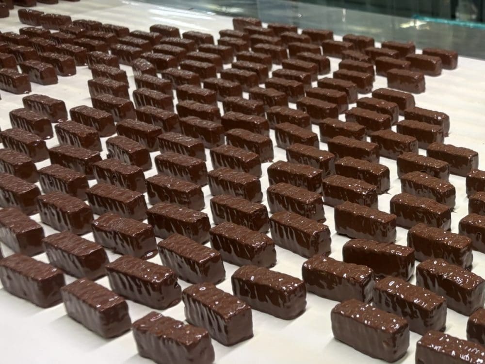 エンローバーという機械でチョコレートをかける