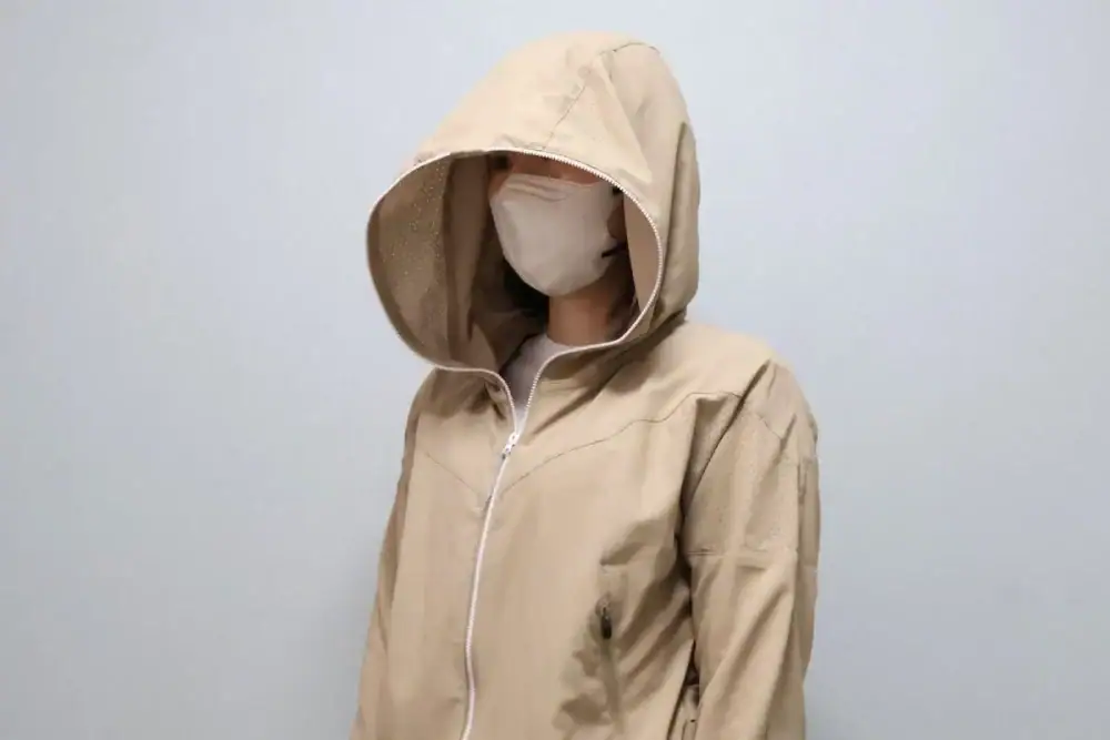 フード付きジャケットとマスクを着用した人物の画像.