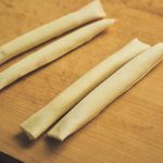 端にトッポを置いてきつめに巻き、小麦粉を水で溶いたのりで閉じる