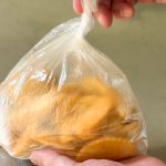 「フライドポテトナチュラルウェッジ」をビニール袋に入れ、タコス用のシーズニングを加え、よく絡ませます