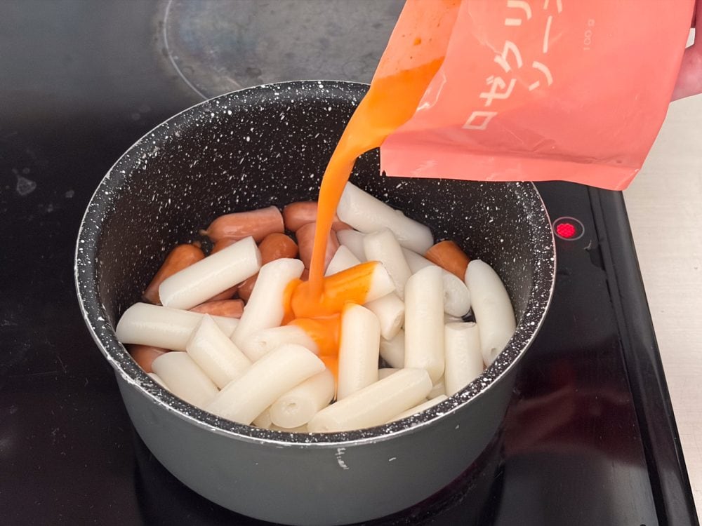 「ロゼクリームトッポギ」は小鍋でソーセージを軽く炒めたら、100mLの水を加え、解凍できたトックとソースを注ぎます