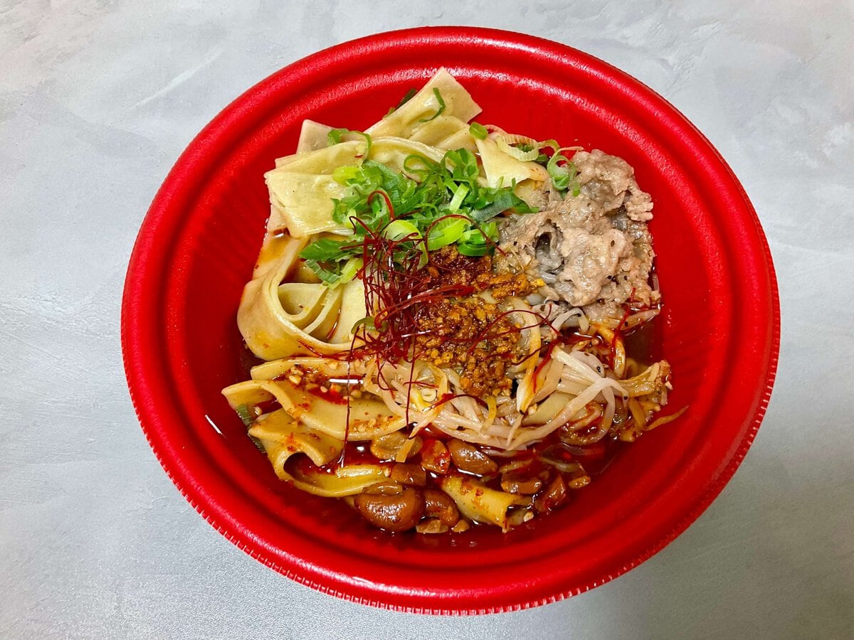牛バラと肉味噌、揚げナッツがトッピングされた麻辣麺