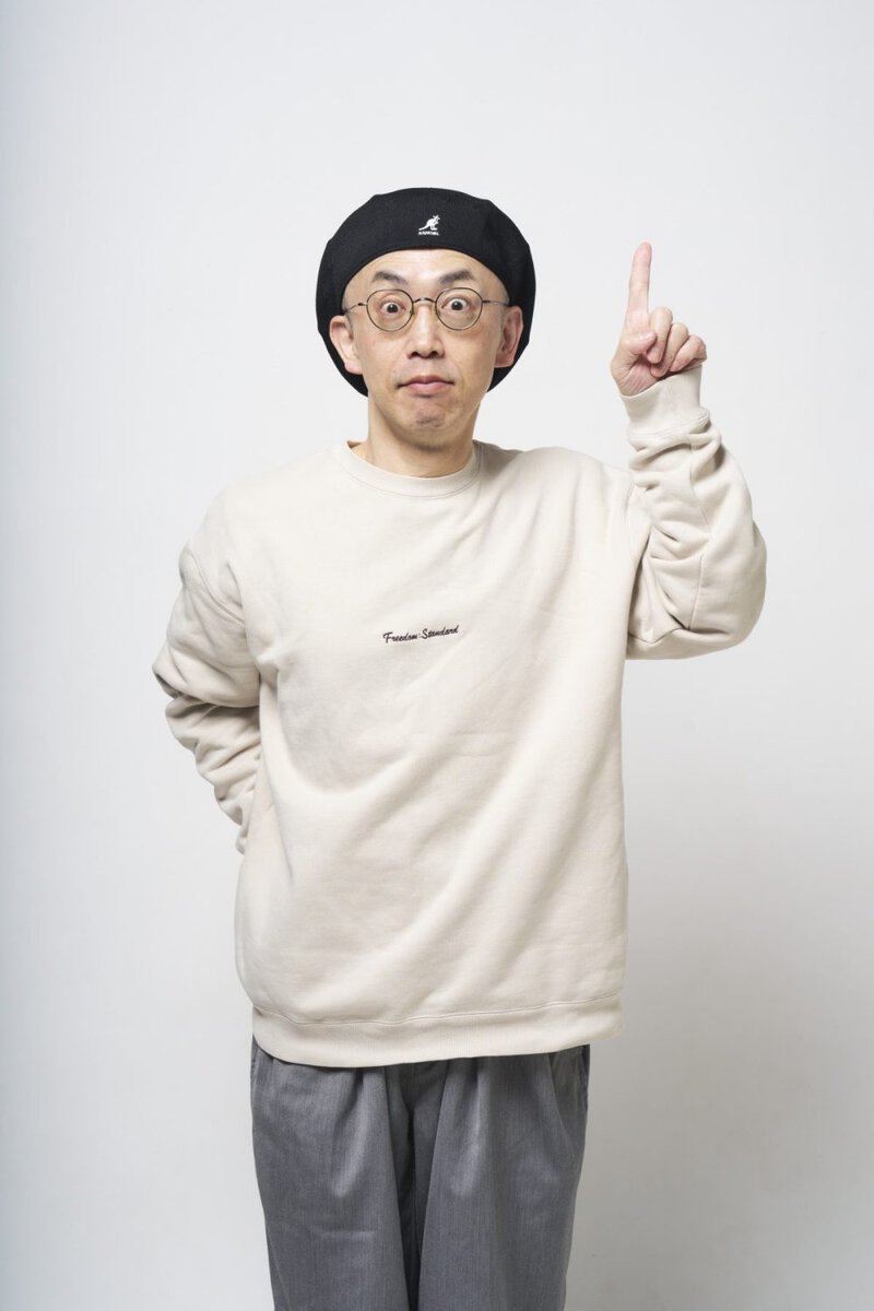 モノマックス公式キャラクターが指を立てているシンプルな白背景の写真.