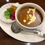 カレーソースは、ライオンのモチーフが付いたフランスの伝統的な食器「ライオントリフボウル」に入っている