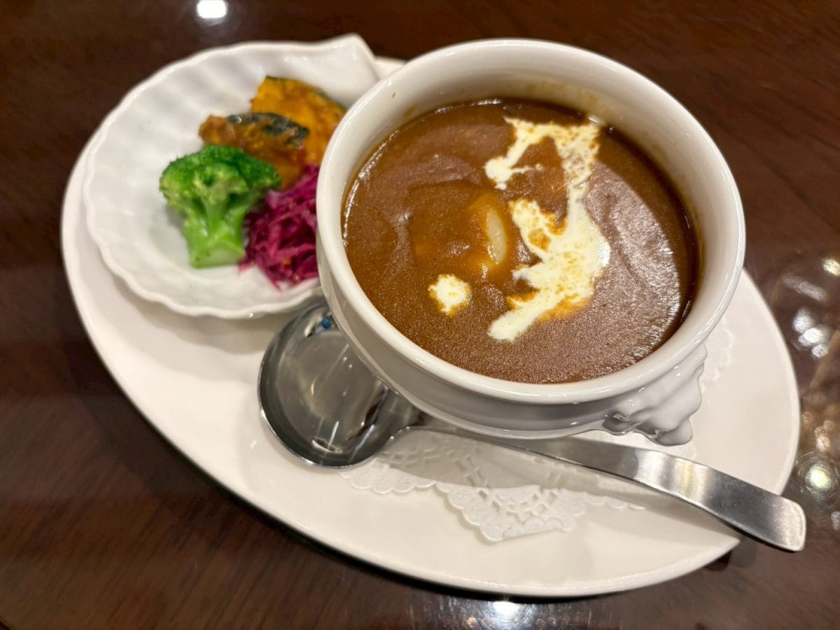 カレーソースは、ライオンのモチーフが付いたフランスの伝統的な食器「ライオントリフボウル」に入っている