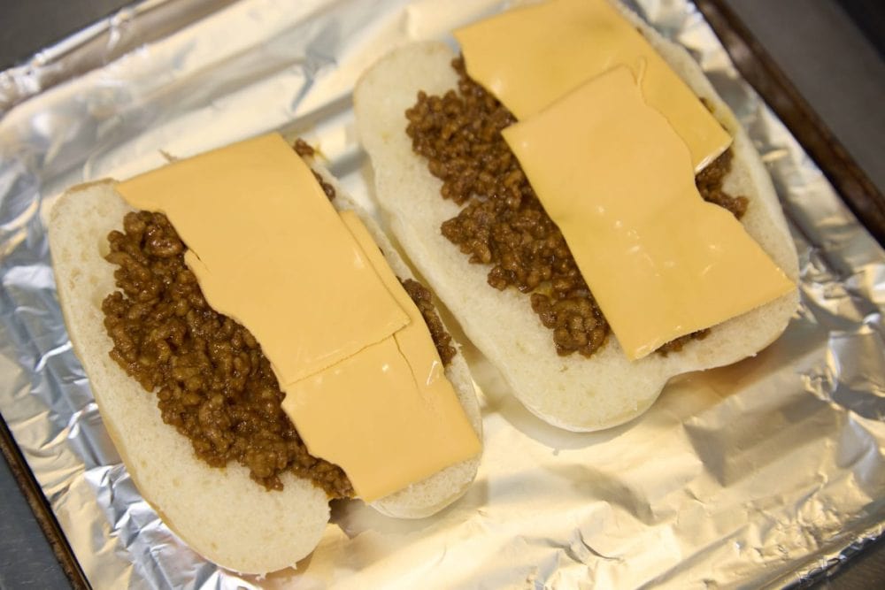 開いたロールパンにチェダーチーズと作った肉をのせてトースターで焼く