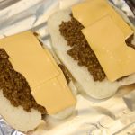 開いたロールパンにチェダーチーズと作った肉をのせてトースターで焼く
