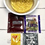 1.「ファミリーマート東京油組総本店 油そば」（日清食品）袋は4つで麺はノンフライ麺。注目は「たまごタレ」と「きざみのり＆ごま」