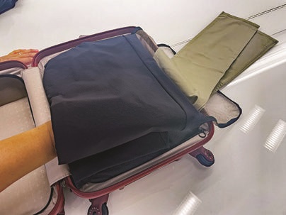 スーツケースのパッキング術：衣類はたたまずに重ねてから包む！